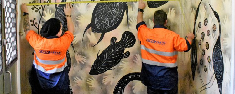 Workers discover an Indigenous artwork and measure it to see if it can be safely removed for transportation